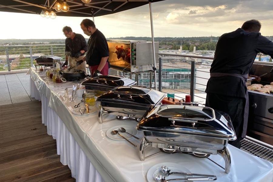 Eine Gruppe von Männern bereitet Essen an einem Buffet zu.