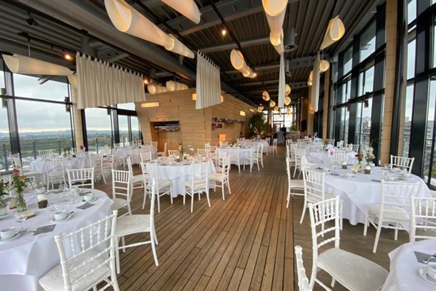 Ein großer Raum mit Tischen und Stühlen für einen Hochzeitsempfang.