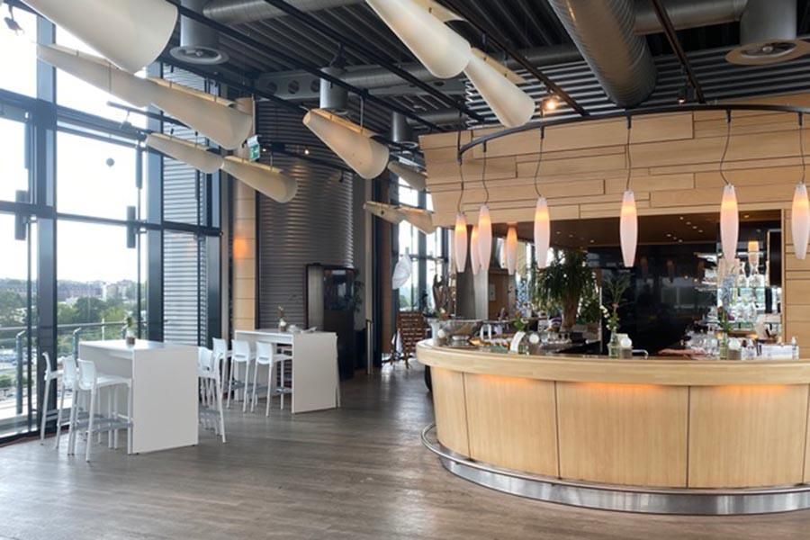 Ein großer Raum mit Tischen und einer Bar in der Mitte