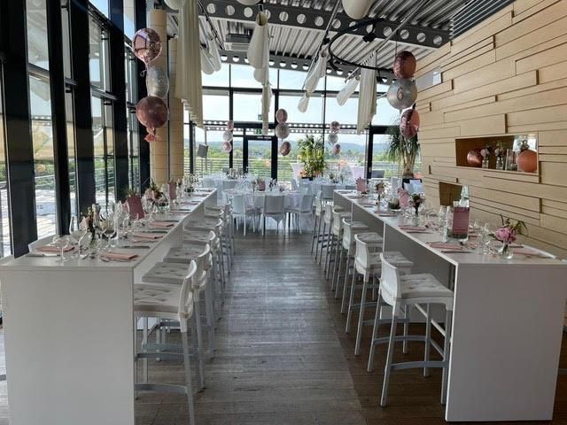 Ein großer Raum mit Tischen und Stühlen und Luftballons, die von der Decke hängen.