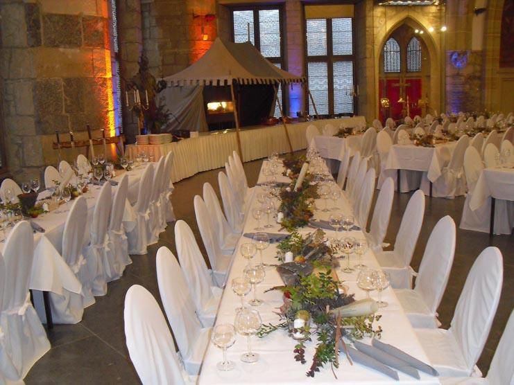 Ein großer Raum mit Tischen und Stühlen für einen Hochzeitsempfang