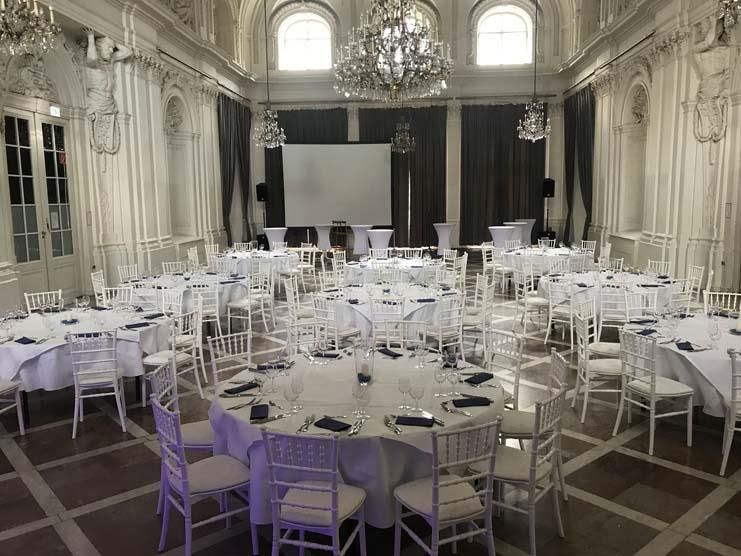 Ein großer Raum mit Tischen und Stühlen für einen Hochzeitsempfang.