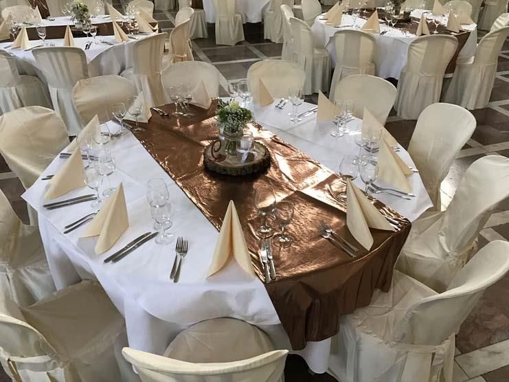 Ein großer Raum mit Tischen und Stühlen für einen Hochzeitsempfang