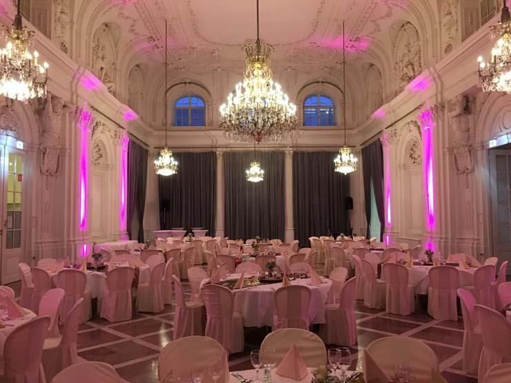 Ein großer Raum mit Tischen und Stühlen für einen Hochzeitsempfang.