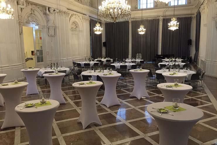 Ein großer Raum mit Tischen und Stühlen für eine Party.