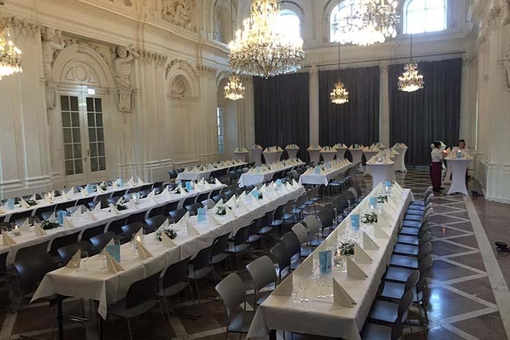 Ein großer Raum mit Tischen und Stühlen für eine Party.