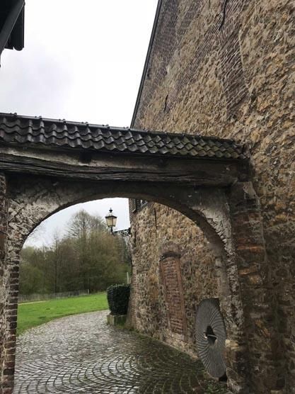 Zwischen zwei Gebäuden befindet sich ein steinerner Torbogen.