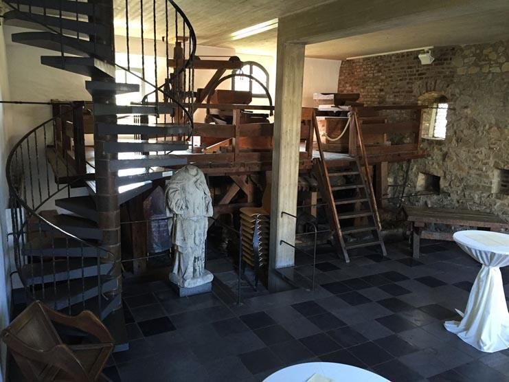 Ein Raum mit einer Wendeltreppe und einer Statue
