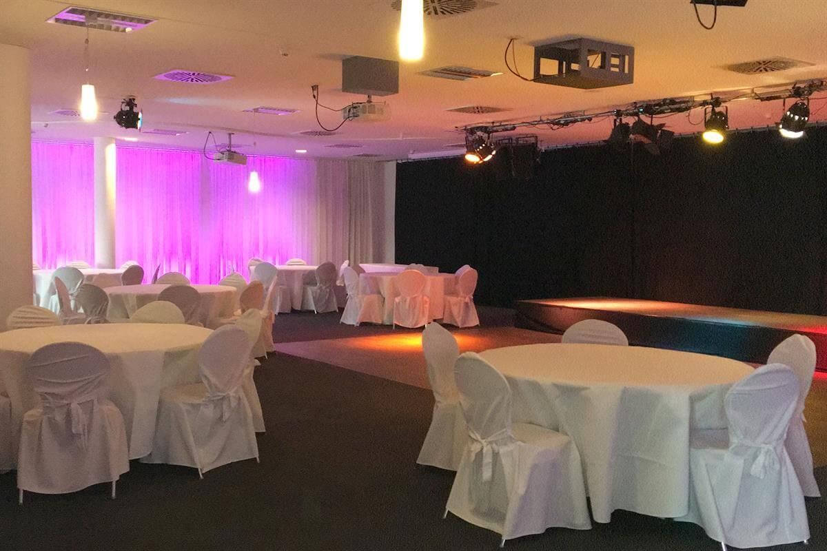 Ein großer Raum mit Tischen und Stühlen für eine Party