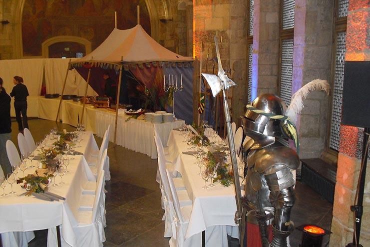 Ein Ritter in Rüstung steht vor einem langen Tisch