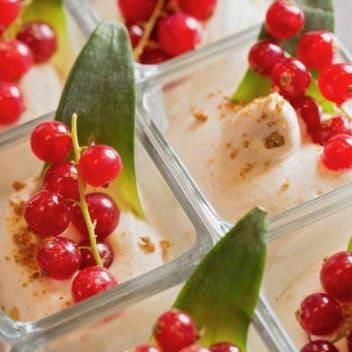 Eine Nahaufnahme eines Desserts mit roten Kirschen und grünen Blättern