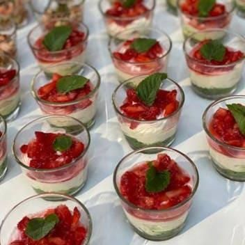 Ein Tisch, gedeckt mit verschiedenen Desserts, darunter Erdbeeren und Minzblätter.