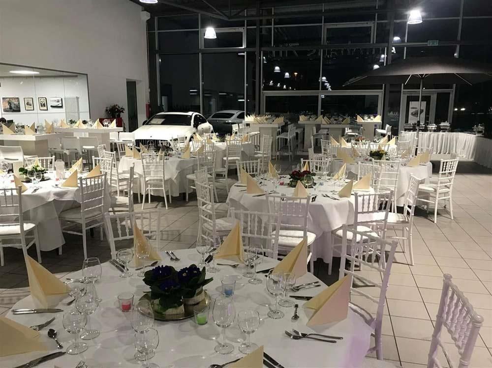 Ein großer Raum mit Tischen und Stühlen für einen Hochzeitsempfang