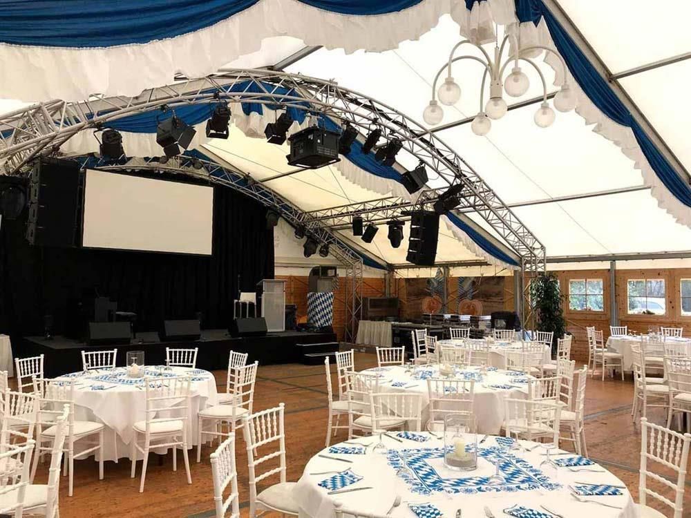 Ein großes Zelt mit Tischen und Stühlen für eine Party.