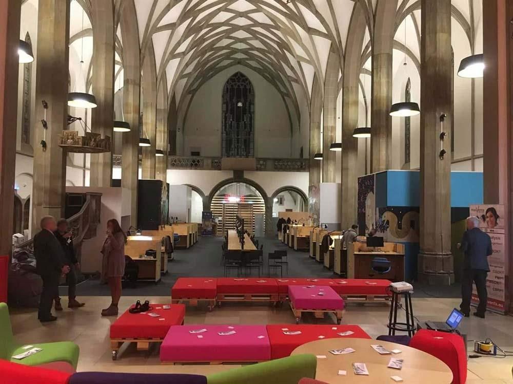 Eine Gruppe von Menschen steht in einem großen Raum in einer Kirche.