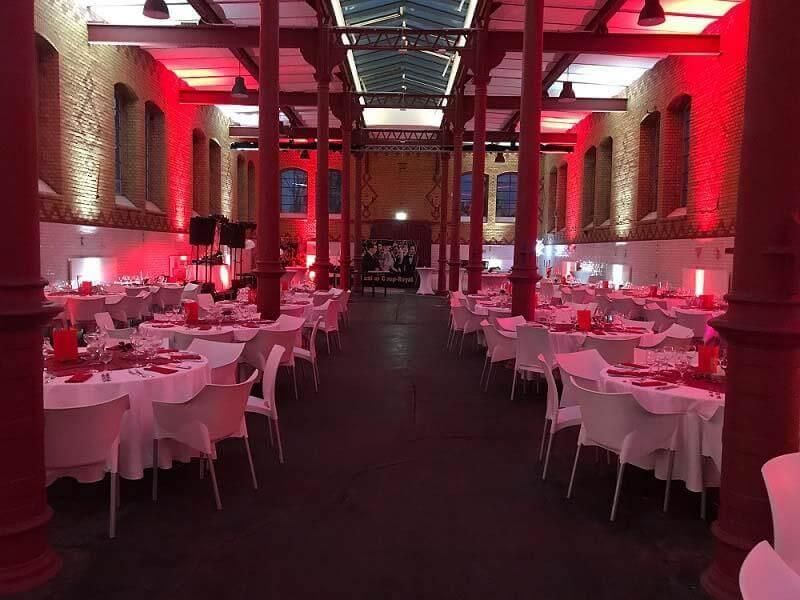 Ein großer Raum voller Tische und Stühle und roter Lichter.