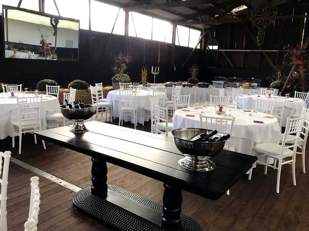 Ein großer Raum mit Tischen und Stühlen für einen Hochzeitsempfang.