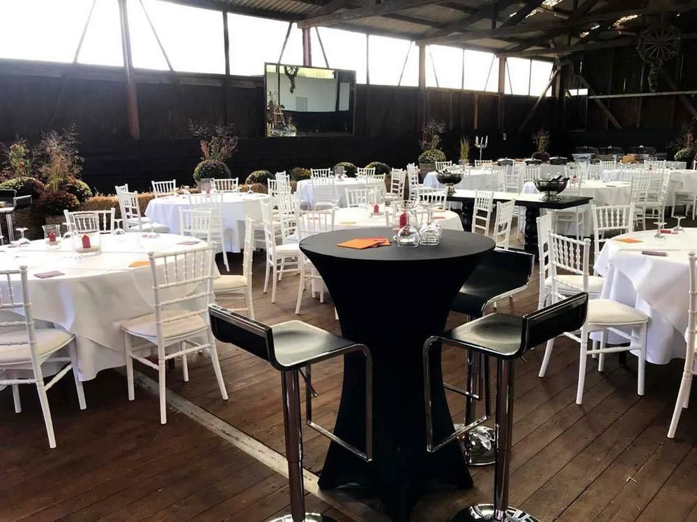 Ein großer Raum mit Tischen und Stühlen für einen Hochzeitsempfang.