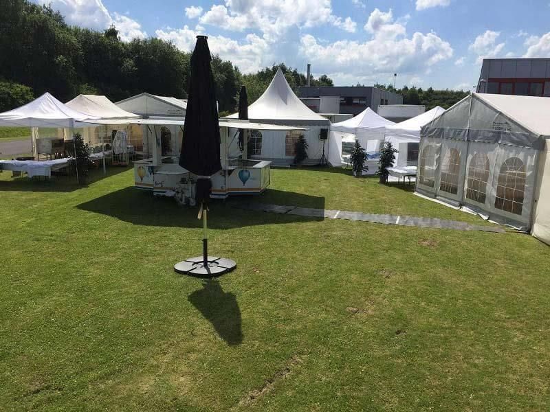 Eine Gruppe Zelte steht auf einem üppigen grünen Feld.