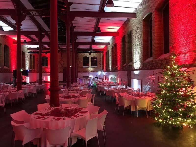 Ein großer Raum mit Tischen und Stühlen und einem Weihnachtsbaum