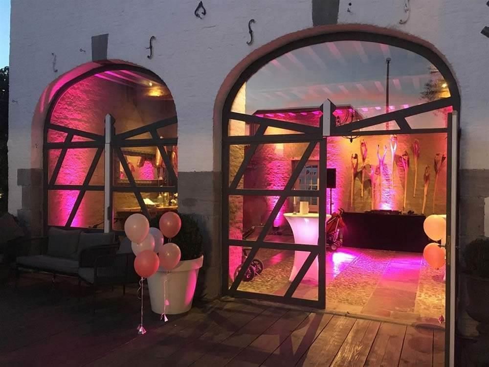 Ein Raum mit rosa Lichtern und Luftballons vor einem Gebäude