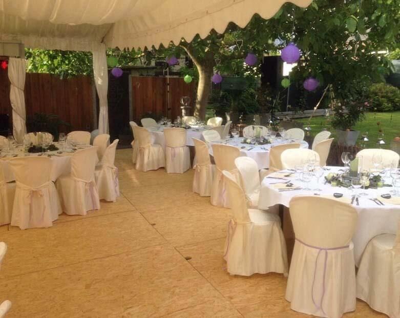 Tische und Stühle sind unter einem Zelt für einen Hochzeitsempfang aufgestellt
