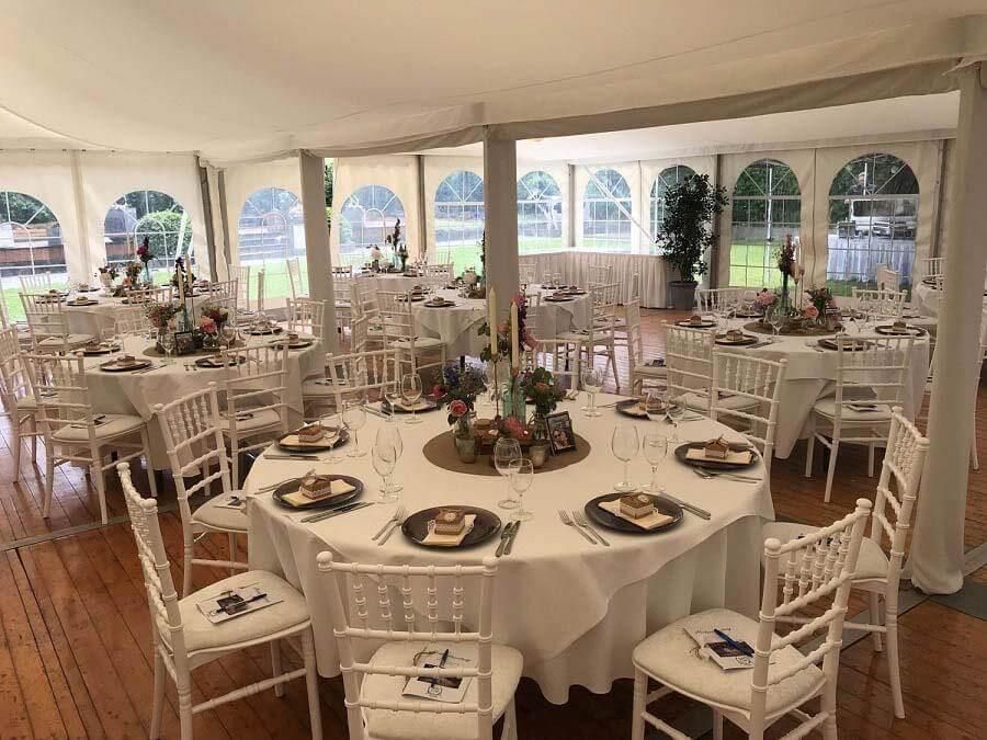 Ein großer Raum mit Tischen und Stühlen für einen Hochzeitsempfang.