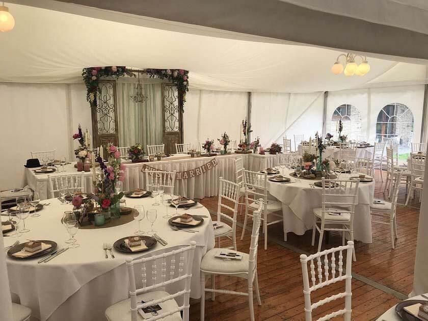 Ein großes Zelt mit Tischen und Stühlen für einen Hochzeitsempfang.