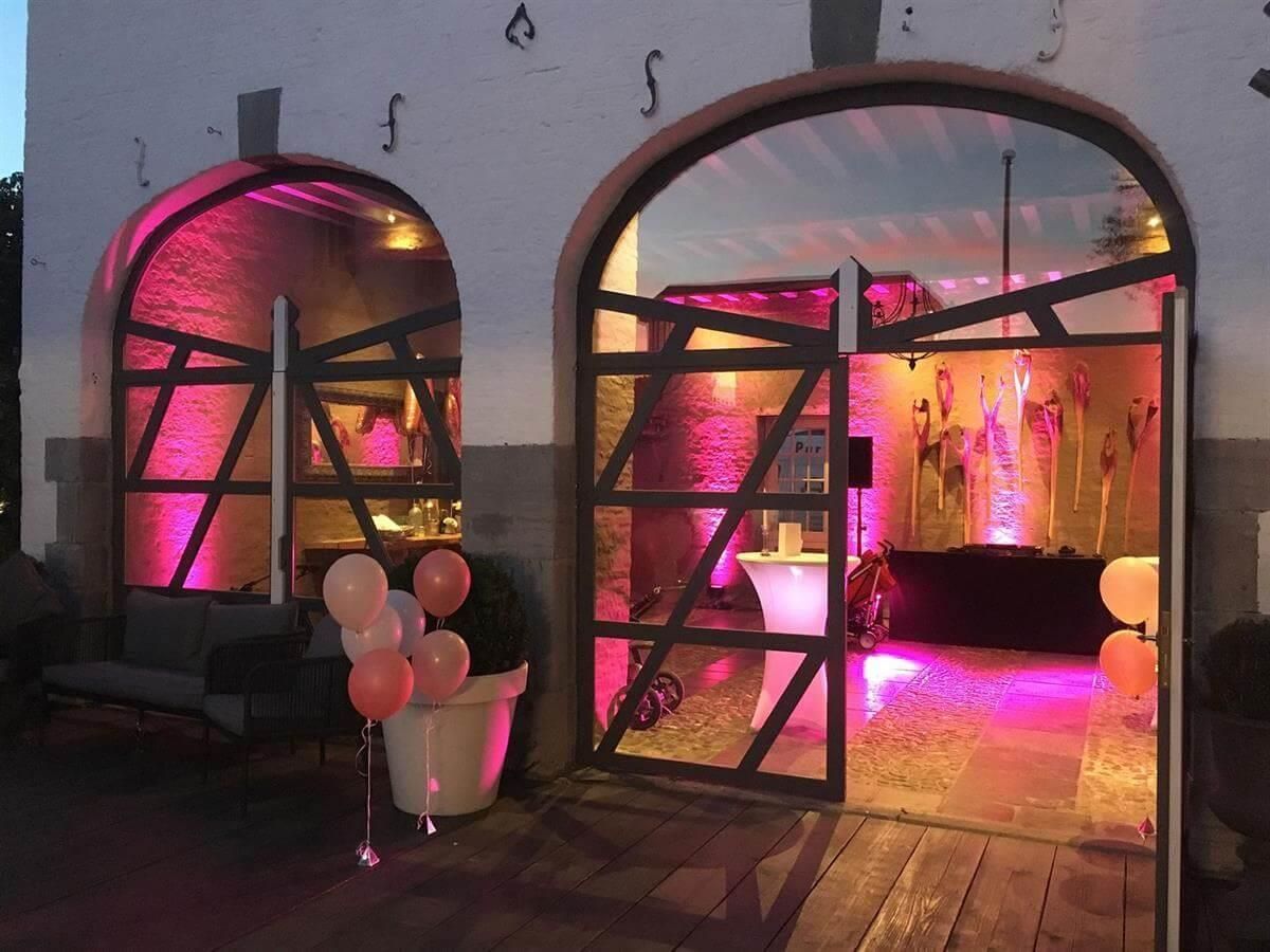 Ein Raum mit rosa Lichtern und Luftballons davor