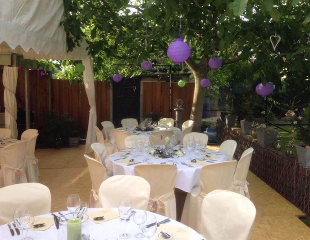 Tische und Stühle sind für einen Hochzeitsempfang unter einem Zelt aufgestellt