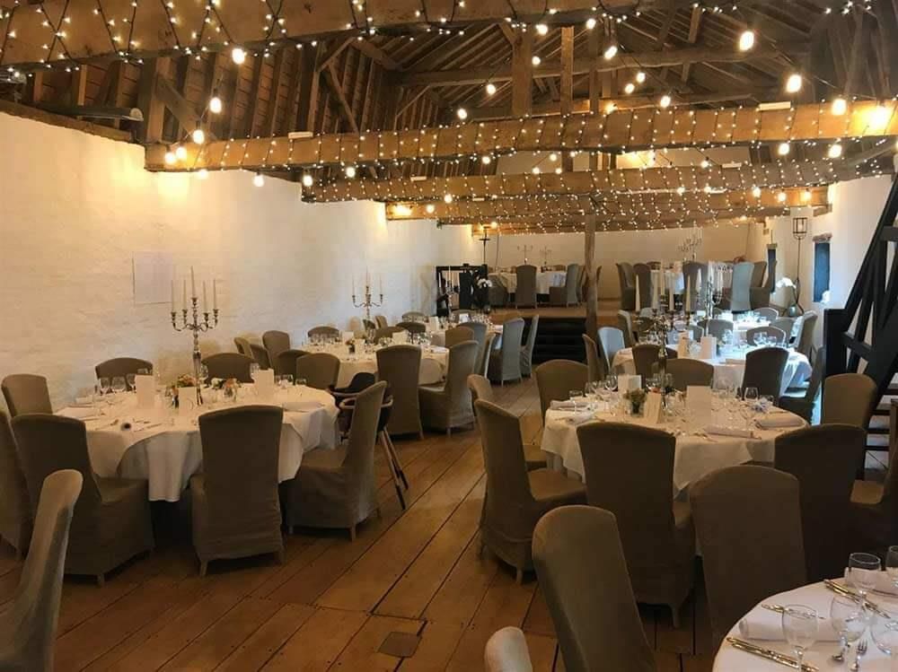 Ein großer Raum mit Tischen und Stühlen für einen Hochzeitsempfang.