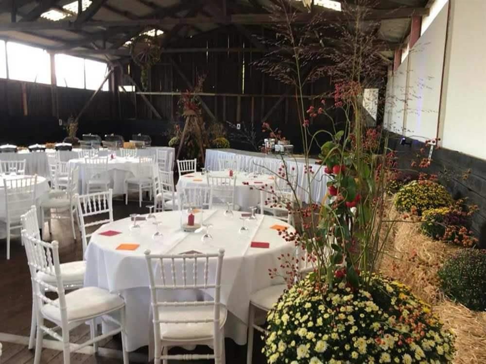 Ein großer Raum mit Tischen und Stühlen für einen Hochzeitsempfang.