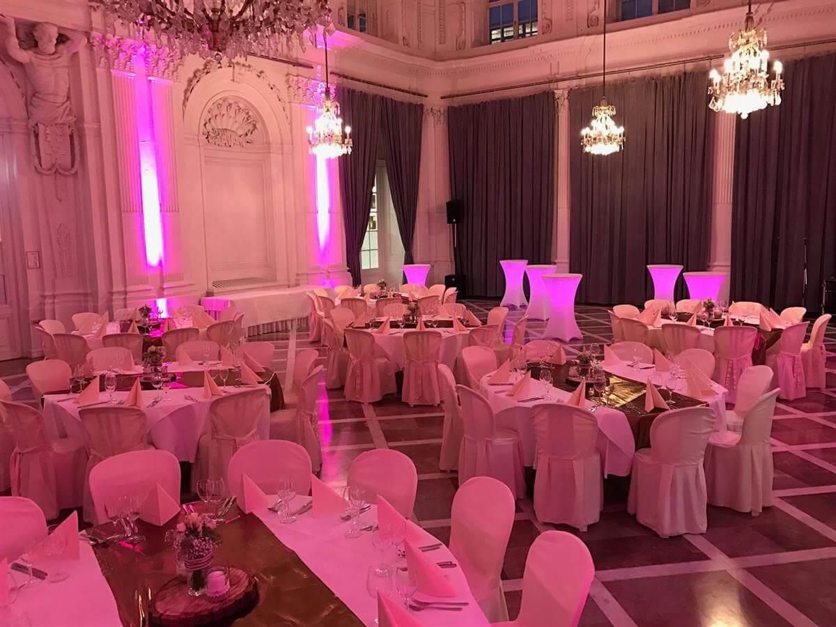 Ein großer Raum mit Tischen und Stühlen für einen Hochzeitsempfang.