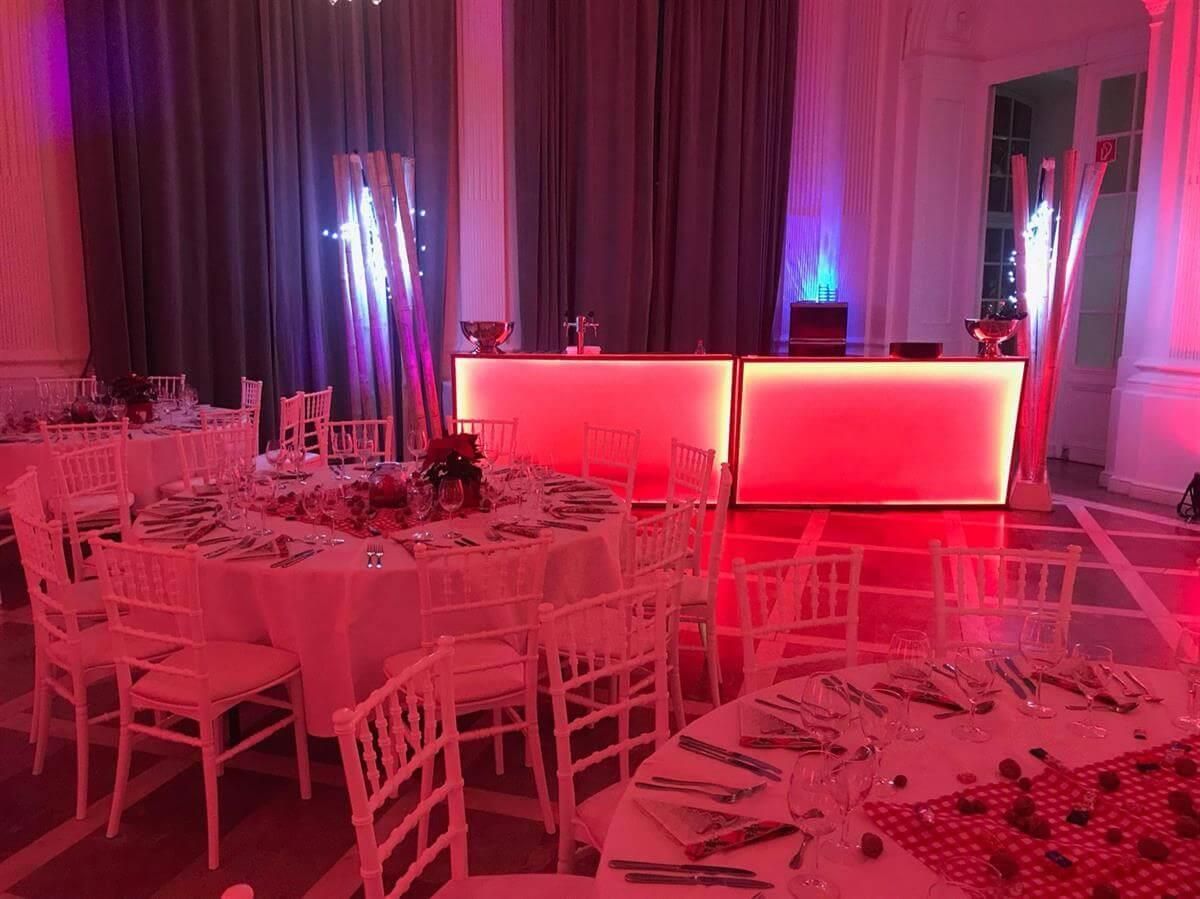 Ein Raum voller Tische und Stühle und roter Lichter.