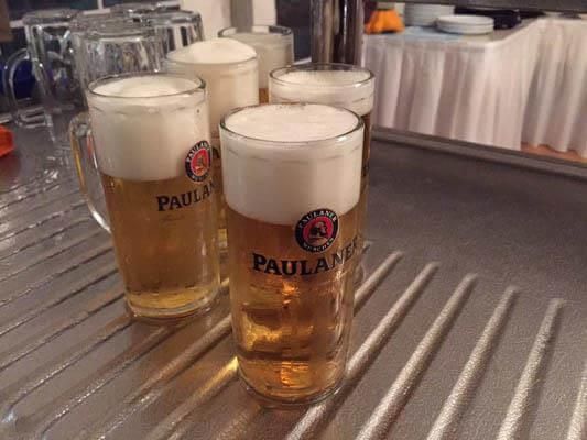 Vier Gläser Paulaner Bier stehen auf einer Theke