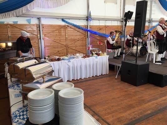 Eine Gruppe Leute spielt in einem Zelt Instrumente.