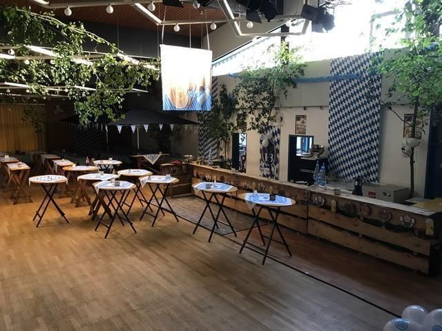 Ein großer Raum mit Tischen und einer großen Leinwand an der Decke.