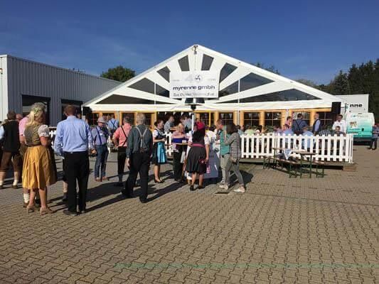 Eine Gruppe von Menschen steht vor einem Gebäude.