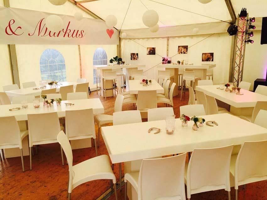 Tische und Stühle in einem Zelt mit einem Schild mit der Aufschrift „Markus“