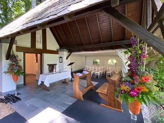 Eine Kirche mit einem Podium und Blumen davor