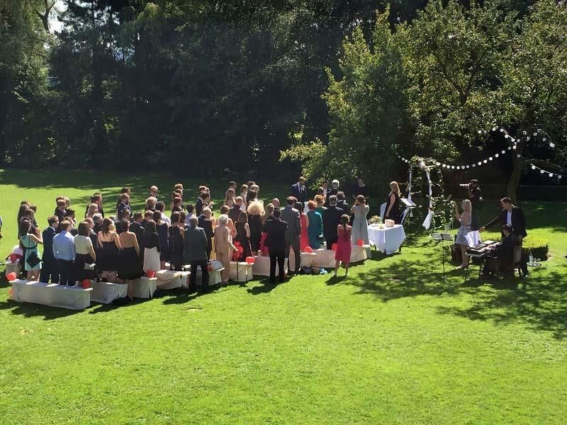 Eine große Gruppe von Menschen steht auf einer Wiese.