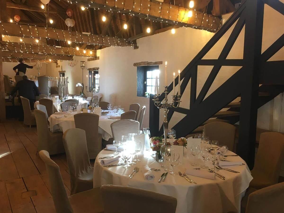 Ein großer Raum mit Tischen und Stühlen für einen Hochzeitsempfang.