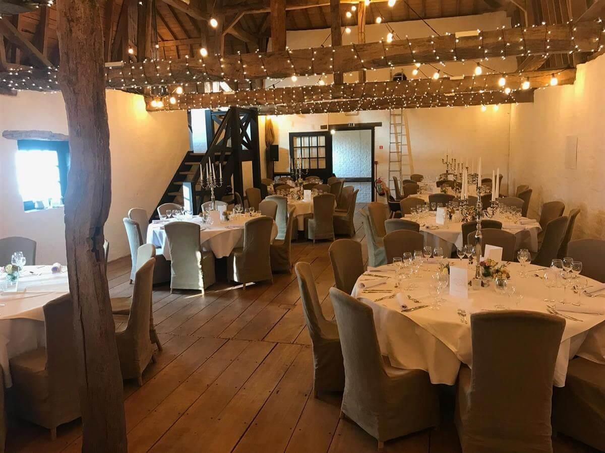 Ein großer Raum mit Tischen und Stühlen für einen Hochzeitsempfang.