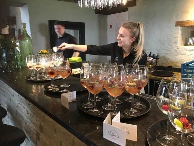 Eine Frau serviert in einer Bar Weingläser.