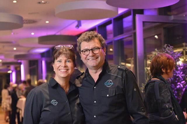 Ein Mann und eine Frau posieren in einem Raum für ein Foto.