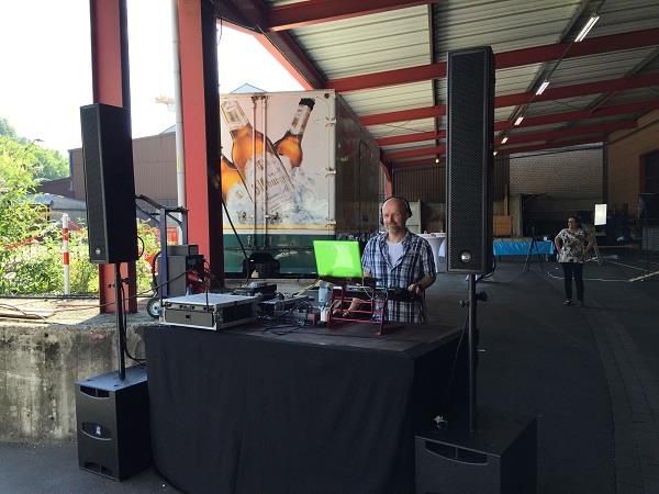 Ein Mann steht vor einem Tisch, auf dem ein Laptop steht.