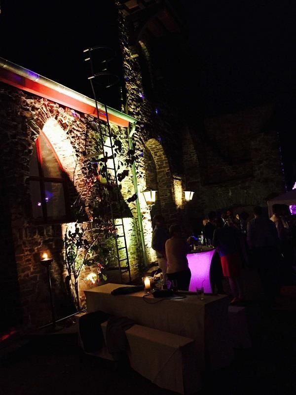 Eine Gruppe von Menschen hat sich nachts vor einem Gebäude versammelt.