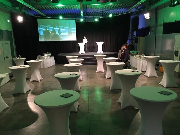 Ein Raum voller Tische und einer Projektionsleinwand