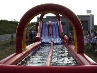 Eine Gruppe Leute spielt auf einer aufblasbaren Wasserrutsche.