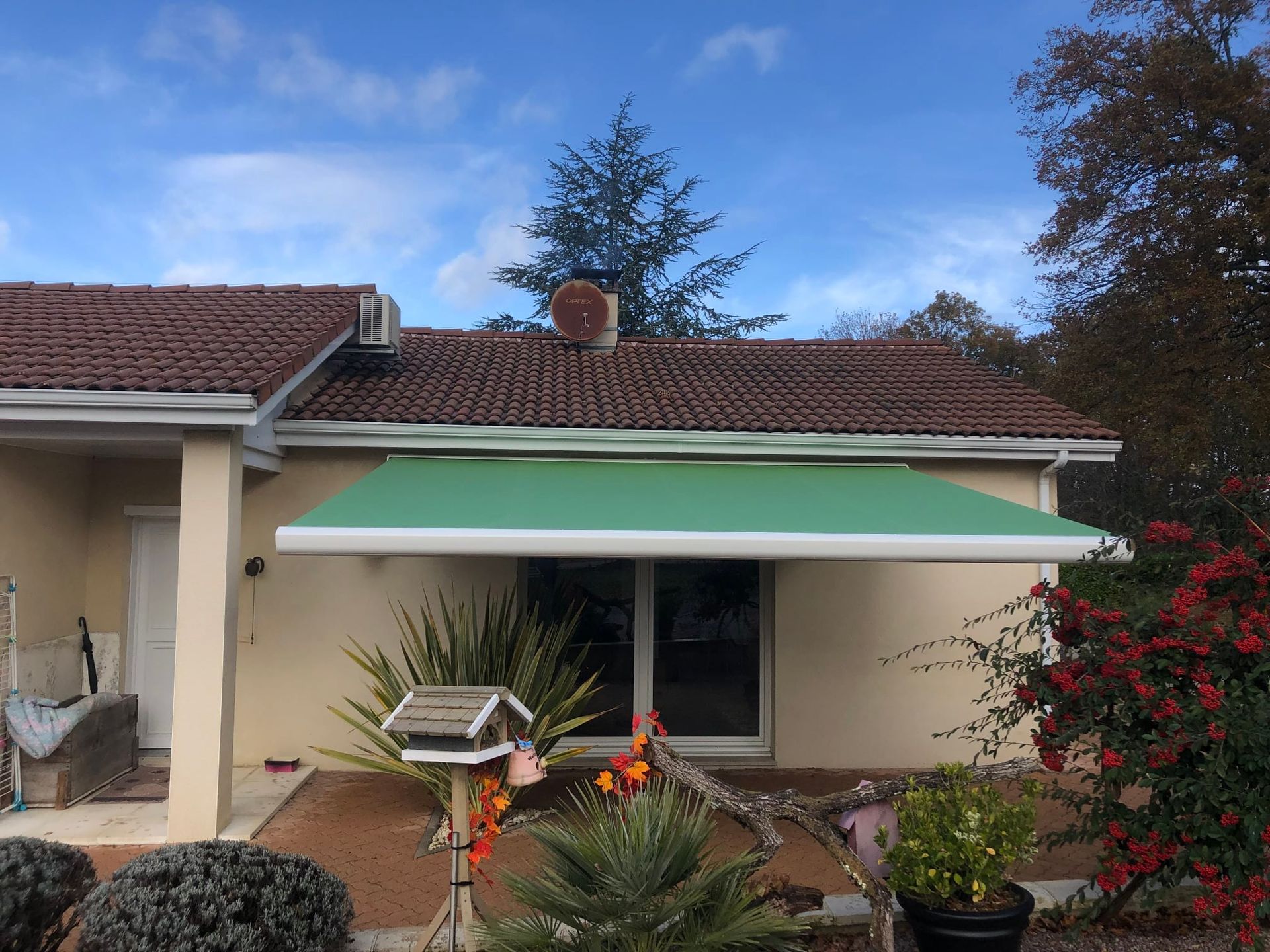 Un store banne vert sur une terrasse